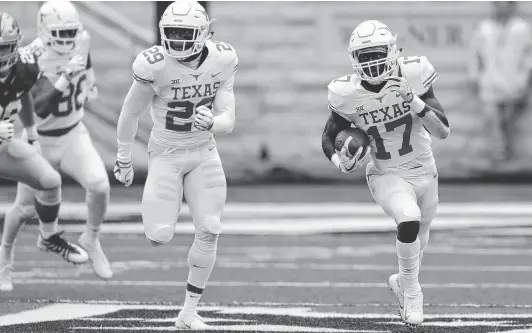  ??  ?? Texas’ D’Shawn Jamison, right, returns a Kansas State punt 90 yards for a touchdown as Josh Thompson deploys as his wingman during the first quarter Saturday.