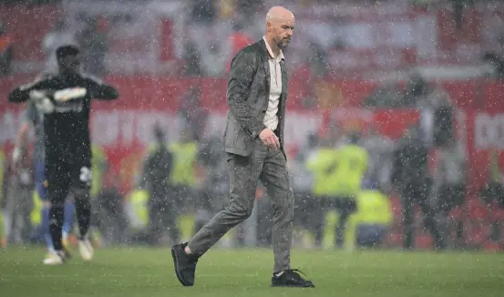  ?? GETTY IMAGES ?? Manchester United manager Erik ten Hag leaves the field amid a downpour after his team’s 1-0 loss to Arsenal in the Premier League.