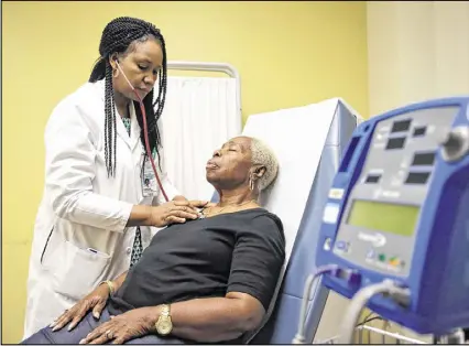  ?? BOB ANDRES / BANDRES@AJC.COM ?? Dr. Ugochi Ohuabunwa, Grady Memorial Hospital’s head of geriatric medicine, examines Doreatha Champion in an exam room in the outpatient clinic. Georgia has a shortage of doctors who specialize in care for senior citizens, even as the number of seniors in the state is exploding.