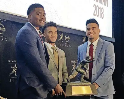  ?? [AP PHOTO] ?? Heisman Trophy finalists, from left, Dwayne Haskins, from Ohio State, Kyler Murray, of Oklahoma, and Tua Tagovailoa, from Alabama, pose with the Heisman Trophy at the New York Stock Exchange on Friday in New York.