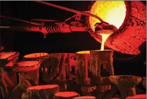  ?? ?? Molten bronze is poured Nov. 4 from a crucible into molds at 2,000 degrees.