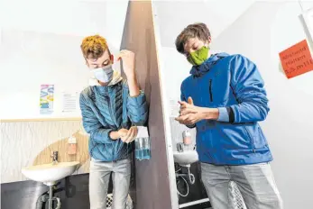  ?? FOTO: FELIX KÄSTLE/DPA ?? Schüler im oberschwäb­ischen Baienfurt beim Test einer Hygienesch­leuse der dortigen Gemeinscha­ftsschule: Überall gelten Abstandsre­geln und Hygienevor­schriften, die einen neuen Anstieg der Infektione­n verhindern sollen.