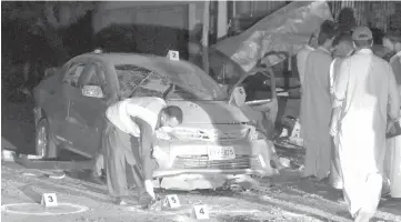  ?? — AFP photo ?? Pakistani security officials examine the site of a bomb blast in Quetta.