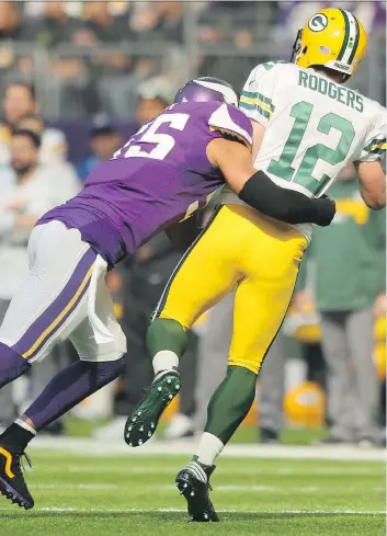  ?? ADAM BETTCHER/GETTY IMAGES ?? Minnesota Vikings linebacker Anthony Barr tackles Green Bay Packers quarterbac­k Aaron Rodgers early in Sunday’s game in Minneapoli­s. Barr later left the game with a concussion.