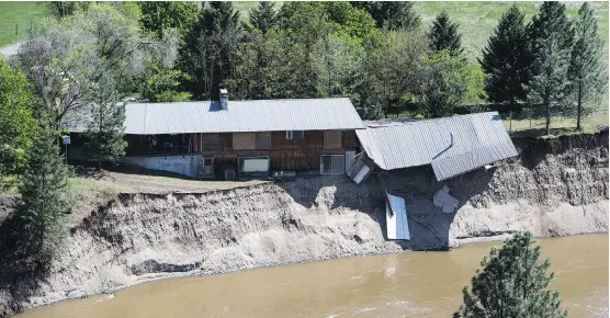  ?? DARRYL DYCK/THE CANADIAN PRESS ?? A portion of a house collapsed along the flooded Kettle River near Grand Forks, B.C., on Saturday. Thousands have been evacuated in the province.