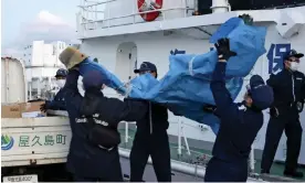  ?? ?? The members of Japanese coast guard carry debris believed to be from the crashed Osprey aircraft. Photograph: êºëœóDëø/AP