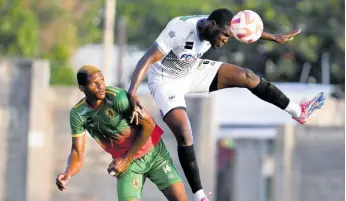  ?? RICARDO MAKYN/CHIEF PHOTO EDITOR ?? Cavalier defender Jeovannie Laing (right) heads the ball away from Humble Lion’s Andre Clennon during a recent Jamaica Premier League match at the Stadium East field. The game ended in a 1-1 draw.