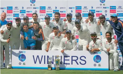  ?? AP ?? Members of Indian team pose with the winning trophy after the win over Bangladesh in their one-off Test match in Hyderabad. —