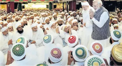  ?? PTI ?? Narendra Modi, along with Syedna Mufaddal Saifuddin, greets members of Dawoodi Bohra community in Indore on Friday. —