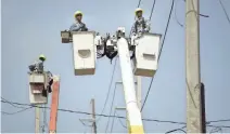  ?? CARLOS GIUSTI/AP ?? Workers repair electrical lines damaged by Hurricane Maria in San Juan, Puerto Rico.