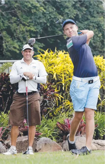  ?? Picture: ANNA ROGERS ?? IT’S ALL RELATIVE: Ky Rankin, 16, tees off on the first hole while his father Craig watches at Cairns Golf Club, each enjoying the challenge of trying to get their handicap down.