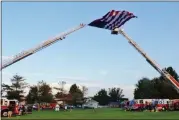  ?? BOB KEELER — MEDIANEWS GROUP ?? The American flag flies between fire truck ladders at Souderton Community Night Out.