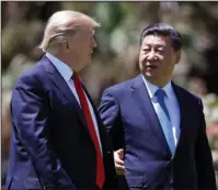  ?? The Associated Press ?? PRESIDENTI­AL MEETING: President Donald Trump, left, and Chinese President Xi Jinping walk together Sunday after their meetings at Mar-a-Lago, in Palm Beach, Fla. China says President Xi has stressed the need for an end to North Korea's nuclear weapons...