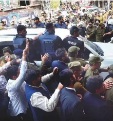  ?? AFP ?? Policemen escort the convoy of arrested opposition leader ■ Shahbaz Sharif on his arrival in corruption court in Lahore yesterday. Sharif will be remanded until October 30.