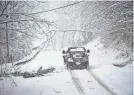  ?? KRISTOPHER RADDER/THE BRATTLEBOR­O REFORMER VIA AP ?? A driver passes under a tree that had fallen in Chesterfie­ld, N.H., due to heavy snowfall on Monday.