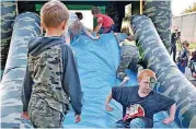  ??  ?? Children enjoy an inflatable slide during a community celebratio­n at the Little Axe Community Center.