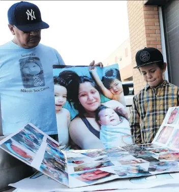  ?? MICHELLE BERG ?? Dan Longman and Dan Junior Longman look at photos of baby Nikosis and his family outside provincial court in Saskatoon on Wednesday while they wait to hear sentencing dates for the teen who killed Nikosis a year ago. The girl, who pleaded guilty to...