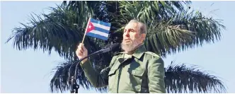  ??  ?? This file photo taken on Jan 26, 2001 shows Castro waving a flag during a visit to the Havana neighborho­od of San Jose de las Lajas.