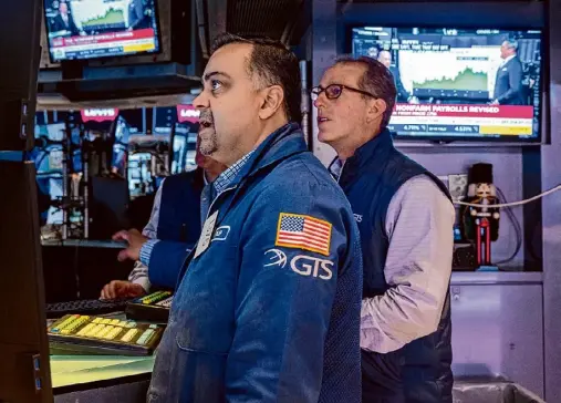  ?? Spencer Platt/getty Images ?? Traders work on the floor of the New York Stock Exchange on Friday in New York. After a week that saw steep drops in the Dow, markets were calm Monday.