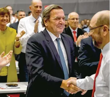  ?? Foto: Sascha Schürmann, afp ?? Gerhard Schröder (Mitte), der Kanzler der Jahre 1998 bis 2005, hat in einer fulminante­n Rede aufgezeigt, wie es geht. Kanzler kandidat Martin Schulz (rechts) dankt ihm für die Ermutigung. Ob er in seine Spuren treten kann?
