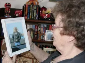  ?? LYNN CURWIN/TRURO DAILY NEWS ?? Carrie Moore looks at a photo of her husband, George, who she lost to cancer in 2016. She now wants to volunteer with the hospice society, an organizati­on that helped her.