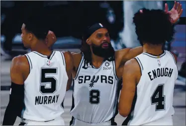  ?? ASHLEY LANDIS — THE ASSOCIATED PRESS ?? San Antonio Spurs’ Dejounte Murray, from left, Patty Mills and Derrick White celebrate after defeating the Memphis Grizzlies on Sunday in Lake Buena Vista, Fla.