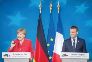  ?? — AFP ?? German Chancellor Angela Merkel and French President Emmanuel Macron give a joint press conference following the European Union leaders summit on Friday.