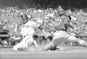  ?? EZRA SHAW — GETTY IMAGES ?? The Giants’ Austin Slater slides safely past the Reds’ Tyler Stephenson to score in the fifth inning at Oracle Park on Wednesday in San Francisco.