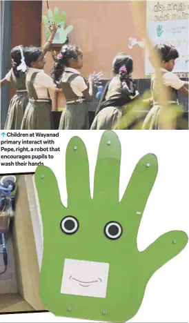  ??  ?? 0 Children at Wayanad primary interact with Pepe, right, a robot that encourages pupils to wash their hands