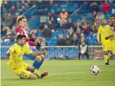  ?? — AFP ?? Atletico Madrid’s Antoine Griezmann (Up) kicks the ball to score beside Las Palmas’ defender Aythami Artiles during the Spanish Copa del Rey (King’s Cup) round of 16 second leg football match Club Atletico de Madrid vs UD Las Palmas at the Vicente...