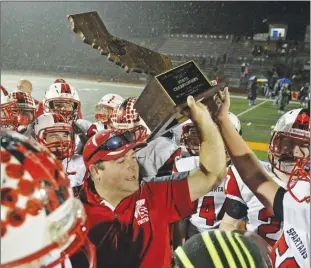  ?? Appeal-democrat file photo ?? Spartans head coach Travis Barker holds up the trophy after the East Nicolaus High football team defeated Coronado 16-6 to win the CIF Division VI-AA state title on Dec. 19, 2015 at Clairemont High in San Diego.