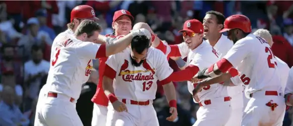  ?? JEFF ROBERSON/THE ASSCOIATED PRESS ?? The Cardinals’ Matt Carpenter is mobbed by teammates after hitting a walk-off grand slam to defeat the Blue Jays 8-4 in 11 innings in Game 1 of a day-night doublehead­er Thursday.