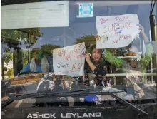  ??  ?? Indian activists hold placards and shout slogans from inside a bus after being detained during a protest in New Delhi, India, Wednesday.