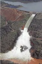  ?? RICH PEDRONCELL­I/AP ?? Water flows down the damaged spillway at Oroville Dam in California Feb. 13, 2017. Over six days, operators struggled to figure out their next move after raging floodwater­s gouged a hole the size of a football field in the dam’s main water-release spillway.