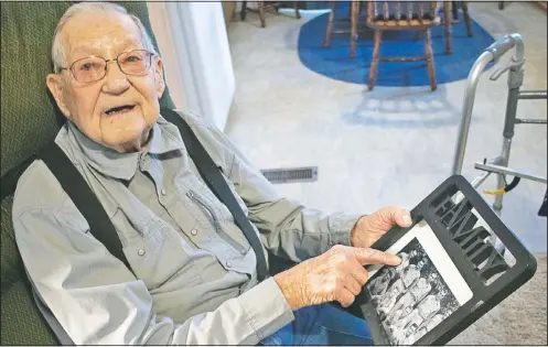  ?? (The Daily Independen­t/Matt Jones) ?? James Chapman shows off a photo of soldiers he served with in the infantry during the Pacific Theater during World War II at his home in Ashland, Ky. Chapman, who turned 100 on Jan. 31, said he dropped out of Louisa High School to voluntaril­y serve in World War II.