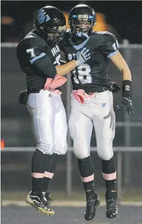  ?? KARL MERTON FERRON/BALTIMORE SUN PHOTO ?? Westminste­r wide receiver Jesse Uhlman, left, leaps to chest-bump Patrick Fitzgerald after Fitzgerald scored the first touchdown in the Owls’ win over North Carroll.