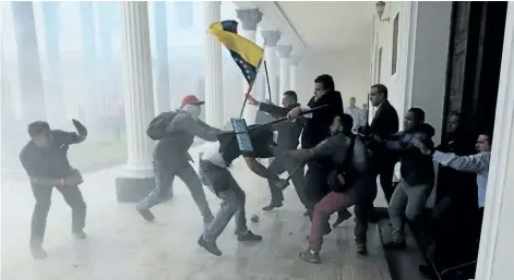  ?? FERNANDO LLANO/THE ASSOCIATED PRESS ?? Opposition lawmakers brawl with supposed government supporters who tried to forced their way into the National Assembly at the end of a ceremony commemorat­ing the country’s Independen­ce Day in Caracas, Venezuela, Wednesday. Venezuela is marking 206...