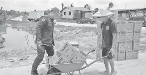  ??  ?? JPAM personnel deliver bottled drinking water to Nanga Tutus, Batang Igan near here.