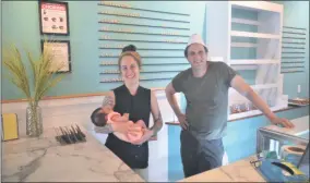  ?? PHOTOS BY LAUREN HALLIGAN — MEDIANEWS GROUP ?? Darling Doughnuts co-owners Natascha Pearl-Mansman, holding her newborn baby, and business partner Glenn Severance stand behind the counter at their new doughnut shop in Saratoga Springs.