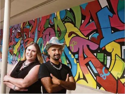  ?? R. Clayton McKee / For the Chronicle ?? Artist Gonzo247 and Pamela Vargas, Rice Village assistant general manager, stand before Gonzo247’s mural “It’s a Good Day to Have a Good Day,” painted on a wall next to the Black Walnut Café, 5510 Morningsid­e Drive.