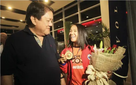  ?? ALDO NELBERT BANAYNAL ?? Cebuana athlete Mary Joy Tabal beams with pride as she shows Cebu City Mayor Tomas Osmeña the gold medal she won for marathon at the Southeast Asian Games in Malaysia. She arrived in Cebu last night.