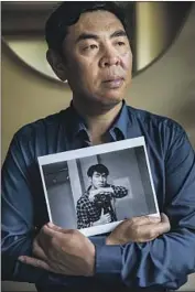  ?? Jay L. Clendenin Los Angeles Times ?? HUALUN WANG, visiting from Sichuan, China, holds a portrait of his son, who died on a film shoot.