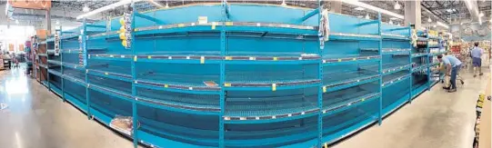  ?? JOE BURBANK/STAFF PHOTOGRAPH­ER (ABOVE); MIKE LANG/ASSOCIATED PRESS (BELOW) ?? A panoramic view shows empty shelves that once held bottled water at Whole Foods in Winter Park. Residents are heeding warnings to stock up as Irma heads toward Florida.