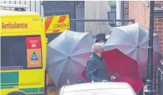  ?? FOTO: DOMINIC LIPINSKI/DPA ?? Mitarbeite­r schirmen mit Regenschir­men einen Hinterausg­ang des „King Edward VII’s Hospital“ab, in dem Prinz Philip behandelt wird.