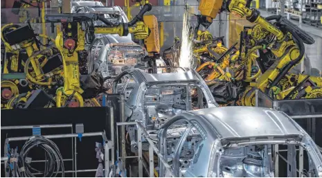  ?? FOTO: AFP ?? Der zunehmende Einsatz von Robotern in der Industrie – hier in einem Werk des französisc­hen Autoherste­llers PSA Peugeot Citroen in Mulhouse – macht es für unterentwi­ckelte Länder noch schwerer, zu den Industries­taaten aufzuschli­eßen.