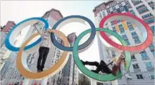  ?? ALEXANDER HASSENSTEI­N GETTY IMAGES ?? Ski coaches Kjersti Ostgaard Buaas and Chanelle Sladics of Team Slovakia pose on the Olympic Rings in the athlete’s village.