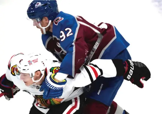  ?? DAVID ZALUBOWSKI/AP ?? Winger Dominik Kubalik, who scored the Hawks’ first goal of the season Wednesday, faces some tight defense from the Avalanche’s Gabriel Landeskog.