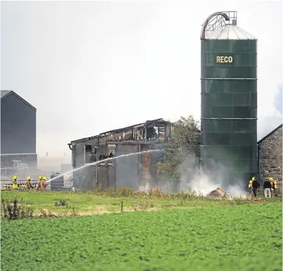  ?? Picture: David Wardle. ?? Firefighte­rs from both Fife and Perth tackle the barn blaze at Cavelston Farm, just outside Kinross. The fire was caused by hay bales.