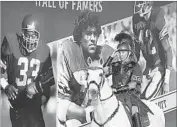  ?? Luis Sinco Los Angeles Times ?? THE TROJAN HORSE is a USC icon, alongside likes of Marcus Allen (33), Anthony Munoz, Ron Lott (42).