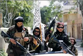  ?? (File Photo/AP/Rahmat Gul) ?? Taliban fighters display their flag Aug. 19 on patrol in Kabul, Afghanista­n.